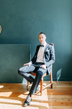  Tarafsız bir arkaplanda ceketli bir adamın portreleri. Mutlu damadın zarif portreleri..