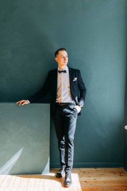  Tarafsız bir arkaplanda ceketli bir adamın portreleri. Mutlu damadın zarif portreleri..