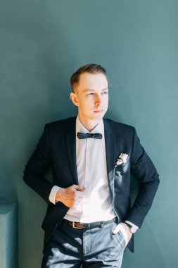  Tarafsız bir arkaplanda ceketli bir adamın portreleri. Mutlu damadın zarif portreleri..