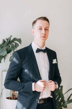  Tarafsız bir arkaplanda ceketli bir adamın portreleri. Mutlu damadın zarif portreleri..