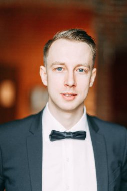  Tarafsız bir arkaplanda ceketli bir adamın portreleri. Mutlu damadın zarif portreleri..