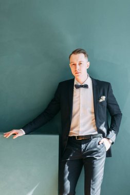  Tarafsız bir arkaplanda ceketli bir adamın portreleri. Mutlu damadın zarif portreleri..