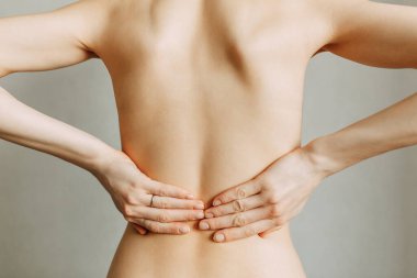 Omurga yaralanması ve iş yerinde yorgunluk. Yaralanma bölgesi, boş bir arkaplandaki görüntü. Kızın sırtında spazm.. 