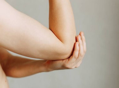 Eklem yaralanmaları, iş yerinde yorgunluk. Yaralanma alanı, temiz bir arkaplanda görüntü. Adamın dirseğine spazm. 