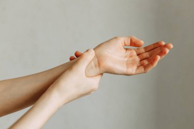 Eklem ve dirsek yaralanmaları, işte yorgunluk. Yaralanma alanı, temiz bir arkaplanda görüntü. Adamın bileğinde spazm.. 