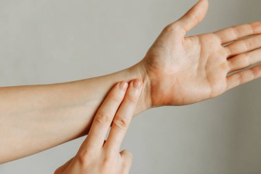 Eklem ve dirsek yaralanmaları, işte yorgunluk. Yaralanma alanı, temiz bir arkaplanda görüntü. Adamın bileğinde spazm.. 