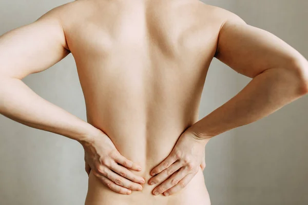 Injuries to the spine and lower back, fatigue at work. Area of the injury, the image on a clean background. Spasm on the man's back.