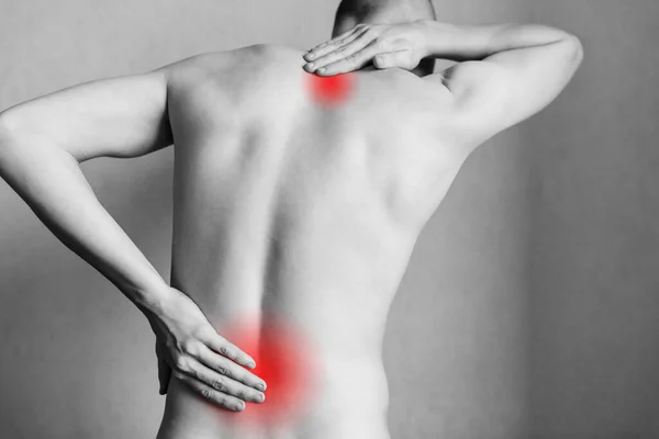Injuries to the spine and lower back, fatigue at work. Area of the injury, the image on a clean background. Spasm on the man's back.