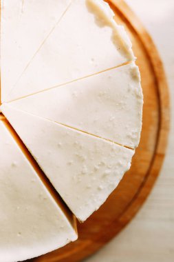  Pasta kısa hamur parçalarına bölünmüş. Tahtada kremalı cheesecake.