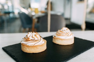 Tatlılarda kısa hamur işi ve garsonun elleri. Kremalı limonlu pasta.. 