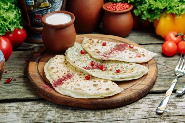 Azerbaycan mutfağı ve restoranda yemek servisi. Ahşap bir tahtanın üzerinde soslu çizburgerler. 
