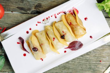  Ahşap arka planda sebzeli restoran yemeği. Et ve sosla doldurulmuş lahana..