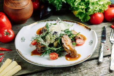  Ahşap arka planda sebzeli restoran yemeği. Biftek filetosu ve roka tabağında salata..