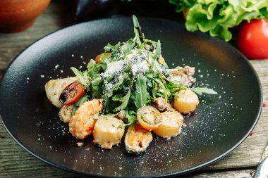  Ahşap arka planda sebzeli restoran yemeği. Karidesli salata, avokado ve roka..