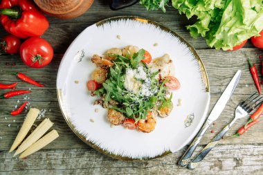  Ahşap arka planda sebzeli restoran yemeği. Karidesli salata, avokado ve roka..