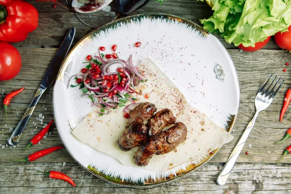 Restaurant dish on a wooden background with vegetables. Azerbaijani pork kidneys with onions on pita bread. — Stock Image Restaurant Dish Wooden Background Vegetables Azerbaijani Pork Kidneys Onions Pita Royalty Free Stock Images