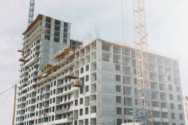  Yüksek binaların yapımında vinçler. Zemin kaplamalarının inşaatı. Katı betondan yapılmış bir binanın inşaatı.