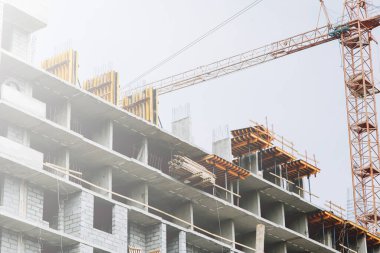  Yüksek binaların yapımında vinçler. Zemin kaplamalarının inşaatı. Katı betondan yapılmış bir binanın inşaatı.