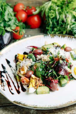 Ahşap arka planda sebzeli restoran yemeği. Biftek filetosu ve roka tabağında salata.. 