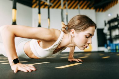 Flexibility exercises on a black background. Stretching in a dark room on a rug. Beautiful girl athlete on the floor. 