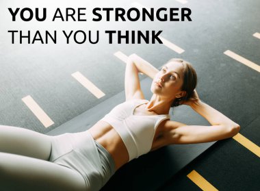 Spor motivasyonu, başarı alıntıları, yoga dersleri. Atletik kız spor salonunda antrenman yapıyor ve esniyor.. 