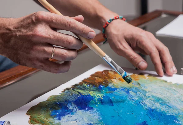 Artist's hand with a brush — Stock Photo, Image