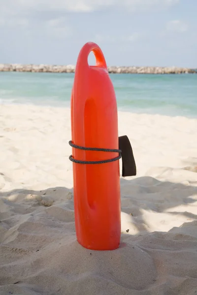 Bouée de sauvetage rouge dans le sable sur la plage — Photo