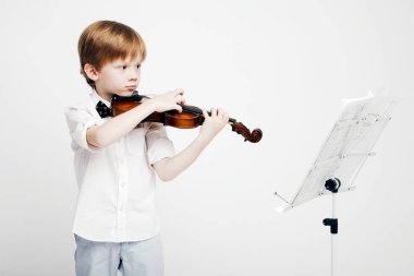 Bir keman onun elinde olan küçük şirin Kızıl saçlı çocuk