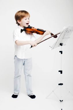 Bir keman onun elinde olan küçük şirin Kızıl saçlı çocuk