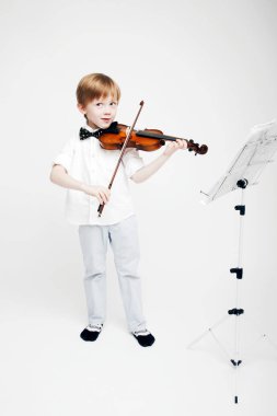 Bir keman onun elinde olan küçük şirin Kızıl saçlı çocuk