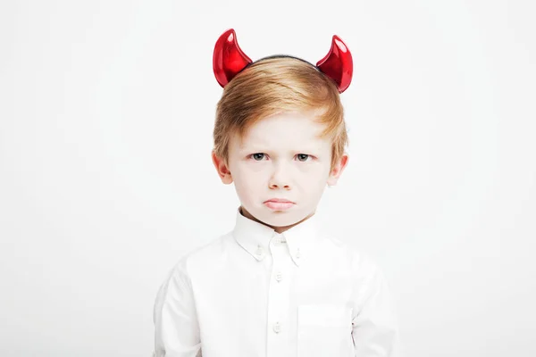 Liten söt känslomässiga pojke med röda horn på huvudet — Stockfoto