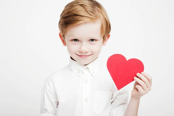 Ładny chłopczyk z czerwonym sercem w rękach — Zdjęcie stockowe