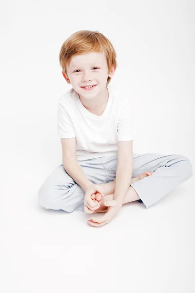 Little cute chłopiec Rudowłosa siedzi na białym tle, w — Zdjęcie stockowe