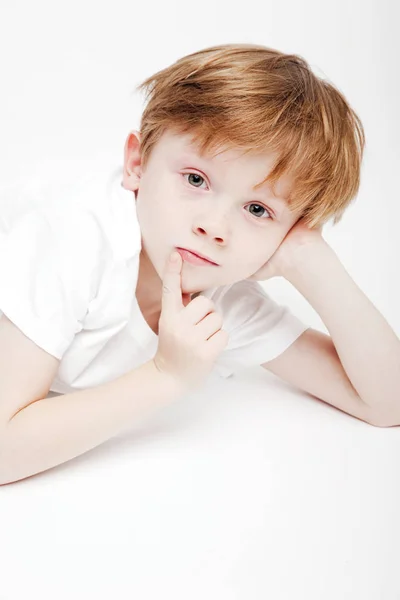 Porträtt av en söt liten pojke på en vit bakgrund — Stockfoto