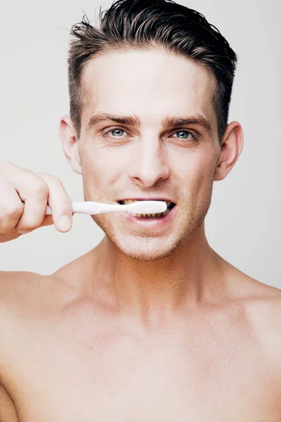 Όμορφος νεαρός άνδρας, βουρτσίζετε τα δόντια του — Φωτογραφία Αρχείου