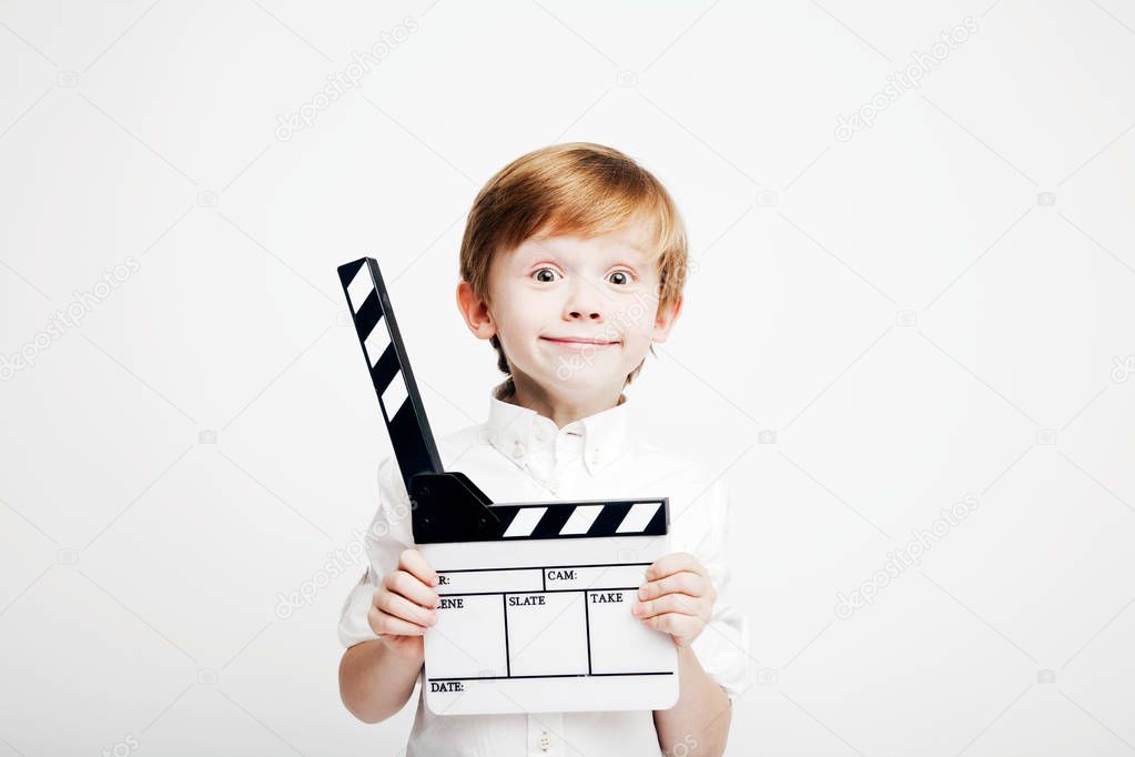 Little cute emotional boy with cinema clapper