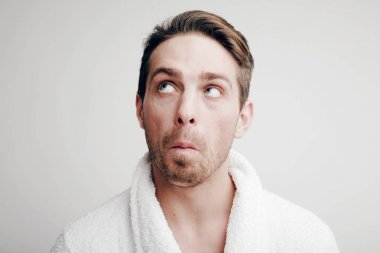 Duygular. Bornoz şaşkın yüzüne olan bir adam portresi