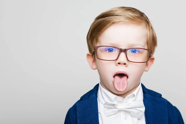 Zrzavý kid s brýlemi zobrazující jazyk — Stock fotografie