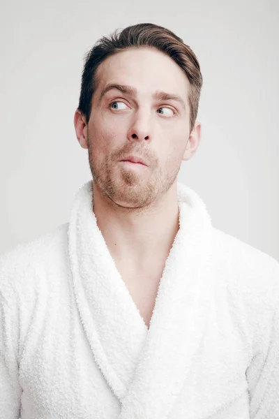 Emotions. Portrait of a Man with a puzzled face in bathrobe