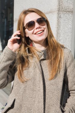 Eğleniyor genç çekici kadın cep telefonuyla konuşuyor