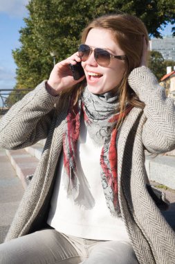 Eğleniyor genç çekici kadın cep telefonuyla konuşuyor