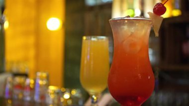 Barmen yeşil içeceği sarı bardakta karıştırıyor.