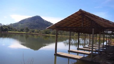 Göl kenarındaki Bambu İskelesi Yeşil Dağ Yansıması