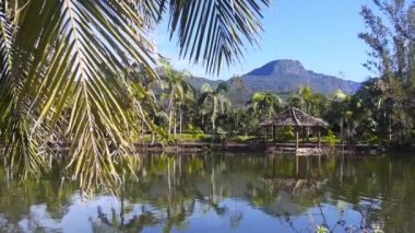 Arka planda yeşil kanyonu olan gölün yanında küçük güzel bir kulübe soldan sağa doğru.