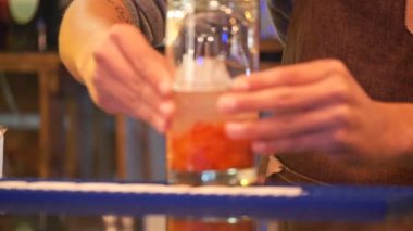 Barmen karıştırmak için ezilmiş çileklerle votka hazırlıyor.