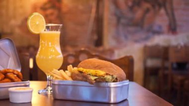 Soğan halkalı sığır burger ve portakal suyu, sağdan sola doğru.