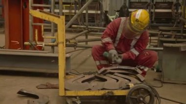 Kırmızı Giysili İşçi ve Sarı Kapaklı Öğütücü Metal Kaydırıcı Soldan Sağa