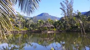 Arka planda yeşil kanyonu olan gölün yanında küçük, güzel bir kulübe.