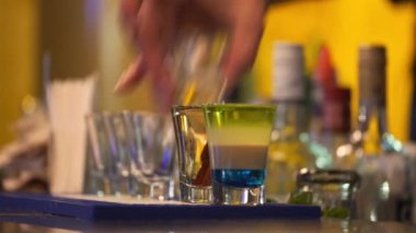 Barmen shot bardağına beyaz rom dolduruyor.