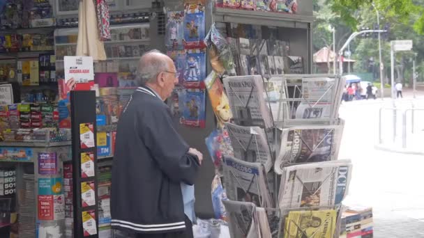 Gammal Man Plockar Tidning Från Street Shop — Stockvideo